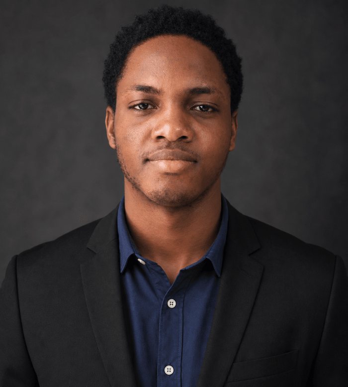 Chisom, founder of Kinetiq Dev, at a desk with a client site on screen